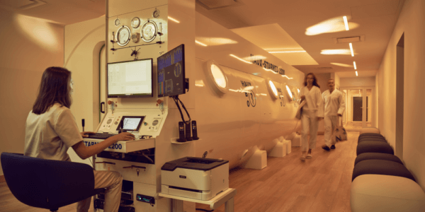 A photograph showing a woman monitoring the hyperbaric chamber’s parameters