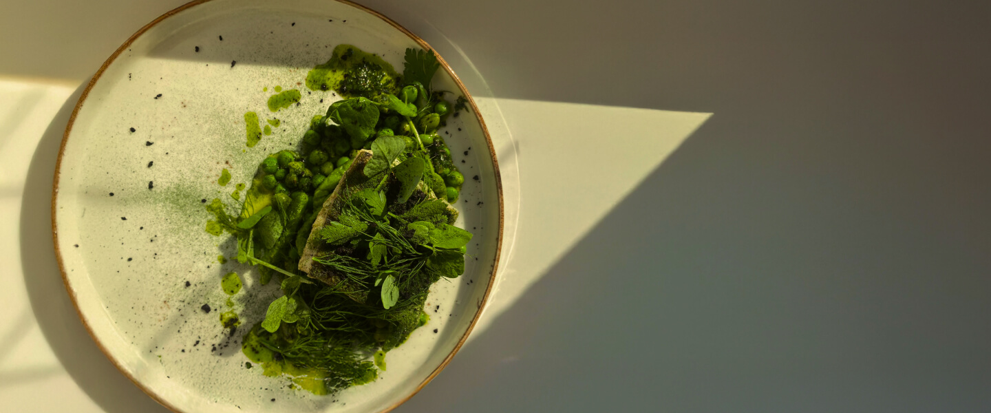 Eleganckie zielone danie z świeżymi ziołami, groszkiem i sosem, starannie podane w NAMI Klinika i Resort Medyczny