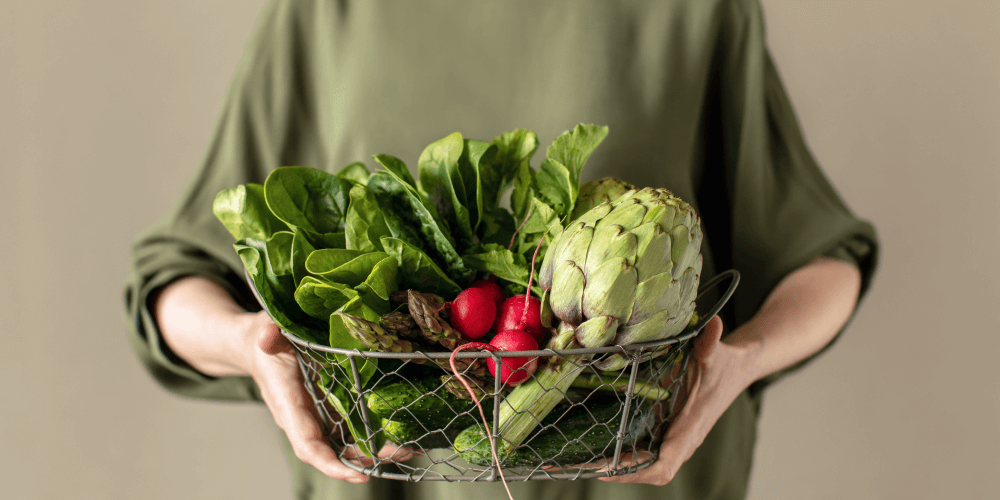 Kobieta trzyma kosz z naturalnymi produktami spożywczymi, które mogą się przyczynić do łagodzenia objawów menopauzy