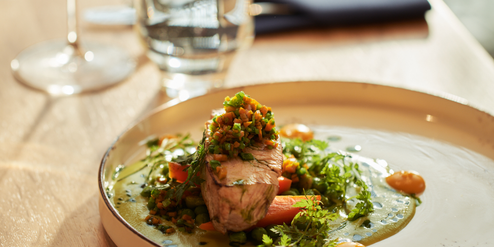 A healthy dish served at NAMI Restaurant – roasted fillet with vegetables and herbs, elegantly presented to support the body’s recovery after physical exertion