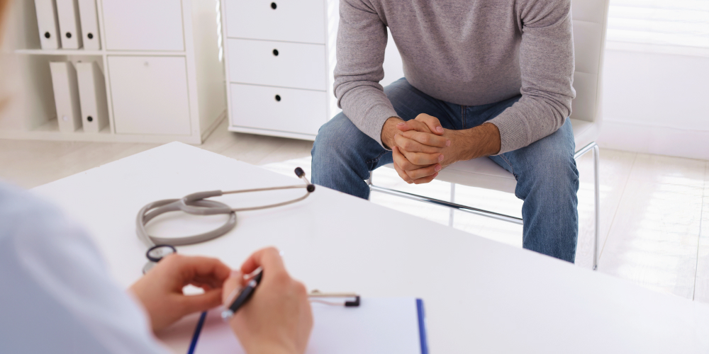 A man discussing prehabilitation and rehabilitation after surgery with a physiotherapist