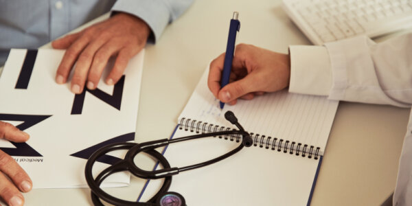 Fizjoterapeuta wypisuje zalecenia pacjentowi do rehabiltacji po zabiegu