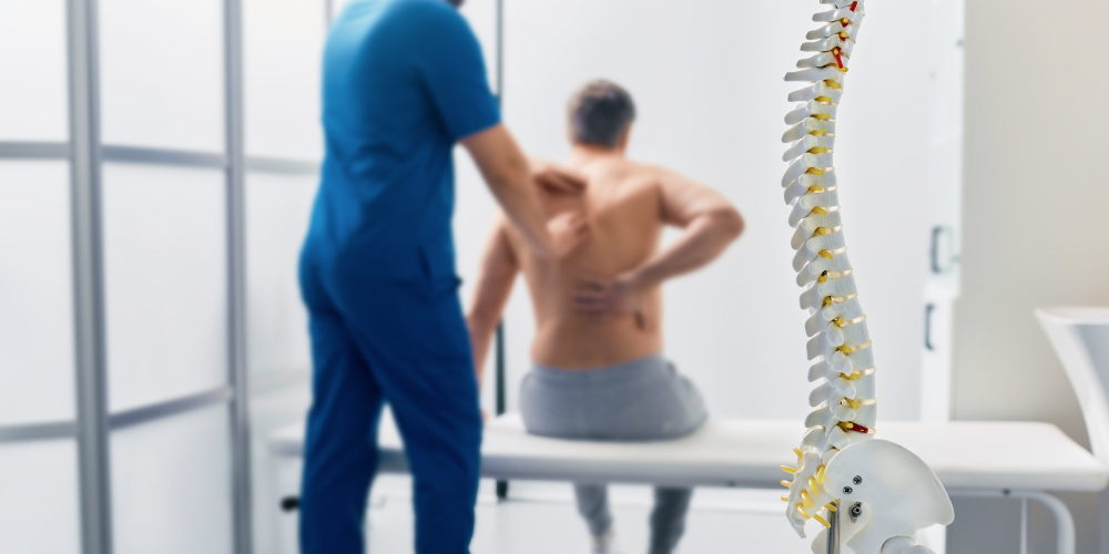 A patient with back pain during a physical therapist consultation.